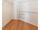 Walk-in closet is equipped with metal racks and shelves and showcases the home's wood flooring at 342 Lakebreeze Cir, Lake Mary, FL 32746