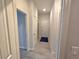 Hallway features neutral walls, and tiled flooring, leading to various rooms, including a laundry closet and entry door at 444 Halter Dr, Apopka, FL 32712