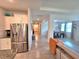 Hallway view looking towards the dining and living room featuring tile floors and stainless steel appliances at 444 Halter Dr, Apopka, FL 32712