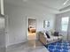Living room features a neutral-toned sofa and tiled floors with a glimpse into the bedroom through an open doorway at 444 Halter Dr, Apopka, FL 32712