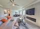 Modern living room with fireplace, TV, ceiling fan, tile floors, and view into the dining room at 444 Halter Dr, Apopka, FL 32712