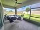 Screened in patio with ceiling fan, modern patio furniture, and view of the fenced backyard at 444 Halter Dr, Apopka, FL 32712