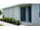 Exterior side entrance featuring a blue door, with manicured landscaping at 444 Halter Dr, Apopka, FL 32712