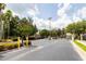 Gated entrance to the community with mature landscaping and trees, offering security and a welcoming atmosphere at 4833 Cypress Woods Dr # 4205, Orlando, FL 32811