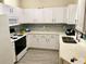 Well-lit kitchen features white cabinets, tile backsplash, and modern appliances at 4833 Cypress Woods Dr # 4205, Orlando, FL 32811