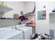 Bright laundry room featuring white washer, dryer, and storage shelving at 4833 Cypress Woods Dr # 4205, Orlando, FL 32811