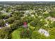 Aerial view of the home surrounded by mature trees and landscaping. A location pin marks the property location at 489 Grape Ave, St Cloud, FL 34769