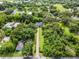 Aerial view of the home and neighborhood, surrounded by abundant trees and greenery at 489 Grape Ave, St Cloud, FL 34769