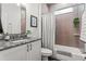 Updated bathroom featuring a granite vanity top, tiled shower, and modern fixtures at 489 Grape Ave, St Cloud, FL 34769
