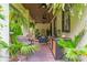 Covered patio with ceiling fans, outdoor kitchen area, comfortable seating, tropical landscaping, and brick floor at 489 Grape Ave, St Cloud, FL 34769