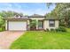 Charming home boasts lush landscaping, manicured lawn and a welcoming brick pathway to the front door at 489 Grape Ave, St Cloud, FL 34769