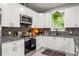 Well-lit kitchen showcases sleek stainless steel appliances, granite countertops, and a decorative tile backsplash at 489 Grape Ave, St Cloud, FL 34769