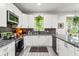 Modern kitchen with sleek cabinets, granite countertops, stainless steel appliances, and ample storage at 489 Grape Ave, St Cloud, FL 34769
