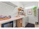 Laundry room features trendy wallpaper, wooden shelves, countertop, and wine fridge at 489 Grape Ave, St Cloud, FL 34769