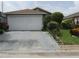 View of a single-Gathering home with a two-car garage and landscaped front yard at 5224 Florida Holly Dr, Orlando, FL 32811