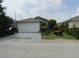 Charming single-story home with a well-maintained lawn and two-car garage at 5224 Florida Holly Dr, Orlando, FL 32811