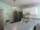 Functional kitchen featuring white cabinetry, stainless steel refrigerator, and tiled floor at 5224 Florida Holly Dr, Orlando, FL 32811