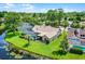 An aerial view of a single-Gathering home with a screened pool, lush greenery, and waterfront views at 526 Sabal Trail Cir, Longwood, FL 32779