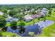 An aerial view of a single-Gathering home with a screened pool, lush greenery, and waterfront views at 526 Sabal Trail Cir, Longwood, FL 32779
