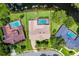An aerial view of a single-Gathering home with a screened pool, lush greenery, and waterfront views at 526 Sabal Trail Cir, Longwood, FL 32779