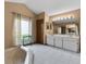 Neutral toned bathroom with tub, window, tiled floor, and double vanity with a large mirror at 526 Sabal Trail Cir, Longwood, FL 32779