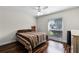 Bedroom with bright window, wood floors, ceiling fan and cozy striped bedspread at 526 Sabal Trail Cir, Longwood, FL 32779