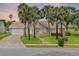 Charming home at sunset featuring palm trees, a brick driveway and walkway, and a well-maintained lawn at 526 Sabal Trail Cir, Longwood, FL 32779