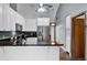 Kitchen featuring granite countertops, stainless steel appliances, white cabinets, and an open doorway at 526 Sabal Trail Cir, Longwood, FL 32779