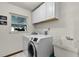 Laundry room featuring modern washer and dryer, utility sink and white cabinetry at 526 Sabal Trail Cir, Longwood, FL 32779