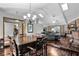 Open-concept living and dining area with hardwood floors, brick fireplace, vaulted ceilings, and a view into the office space at 526 Sabal Trail Cir, Longwood, FL 32779