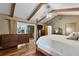 Vaulted ceiling, exposed wood beams, wood floors, and access to the outdoor space in the main bedroom at 526 Sabal Trail Cir, Longwood, FL 32779