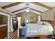 Main bedroom with hardwood floors, exposed beams, and private bath access at 526 Sabal Trail Cir, Longwood, FL 32779