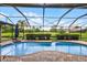 Screened pool area with brick patio and view of the pond and green at 526 Sabal Trail Cir, Longwood, FL 32779