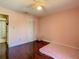 Simple bedroom with a twin bed, hardwood floors, closet and a ceiling fan at 5395 Vineland Rd # S, Orlando, FL 32811