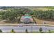 A pristine community pool is shown from an aerial view surrounded by lush landscaping and blue sun umbrellas at 5639 Timber Meadow Way, St Cloud, FL 34771