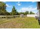 Spacious fenced backyard features lawn space, power lines, lush trees, and functional storage sheds at 5639 Timber Meadow Way, St Cloud, FL 34771