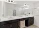Bright bathroom featuring a double vanity with dark cabinets, bright countertops, and a glass-enclosed shower at 5639 Timber Meadow Way, St Cloud, FL 34771