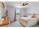 Bedroom features a window, ceiling fan, a light pink blanket, and wooden furniture at 5639 Timber Meadow Way, St Cloud, FL 34771