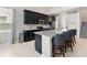 Kitchen features a large island with bar seating, dark cabinets, and stainless steel appliances at 5639 Timber Meadow Way, St Cloud, FL 34771