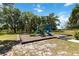 A neighborhood playground featuring vibrant play structures amid towering trees and lush green landscaping at 5639 Timber Meadow Way, St Cloud, FL 34771