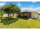 Exterior view showing the screened-in patio and grassy backyard at 6005 Coal Ct, St Cloud, FL 34772