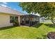 Home exterior with a view of the screened in lanai and manicured lawn at 6005 Coal Ct, St Cloud, FL 34772