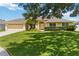 Charming single-story home featuring a well-manicured lawn, mature landscaping, and an attached two-car garage at 6005 Coal Ct, St Cloud, FL 34772