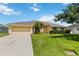 Charming single-story home features a lush front yard with tropical palm trees and an attached two-car garage at 6005 Coal Ct, St Cloud, FL 34772