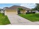 A delightful single-Gathering home with a well-kept front lawn, mature tree and a two-car garage at 6005 Coal Ct, St Cloud, FL 34772