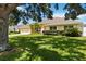 Inviting single-story home featuring a well-manicured lawn, mature landscaping, and a welcoming facade at 6005 Coal Ct, St Cloud, FL 34772