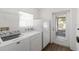 Bright laundry area features a washing machine, dryer, refrigerator, and natural light at 6005 Coal Ct, St Cloud, FL 34772