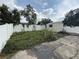Backyard with a shed, a white fence, and concrete patio needs some yard work at 7104 Blue Earth Ct, Orlando, FL 32818