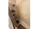 Tiled bathroom with bathtub and shower, featuring shower rack and a rubber bath mat at 7104 Blue Earth Ct, Orlando, FL 32818