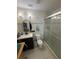 Tiled bathroom features a glass shower, and a vanity with dark wood cabinets and an oval mirror at 7104 Blue Earth Ct, Orlando, FL 32818